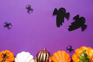 Halloween-achtergronden van witte, oranje en gouden pompoenen, spinnen en zwarte geest op een paarse achtergrond met spinnenwebben en vreselijke landschappen. horror en een enge vakantie met kopieerruimte