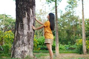 Aziatische vrouwen knuffelen bomen, het concept van liefde voor de wereld foto