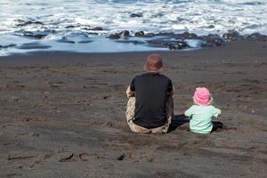 tenerife, spanje, 2011. vader en dochter kijken naar de golven foto