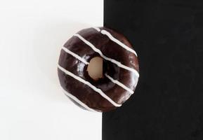 bovenaanzicht, chocolade donut op zwart witte achtergrond foto