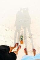 zomer strandvakantie met ananas en slippers op het strand foto