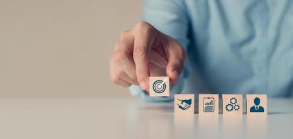 hand woods block cube met pictogram bedrijfsstrategie-ontwikkeling, conceptsucces en zakelijke doelen foto