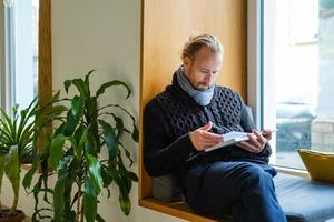 knappe man lees boek en werk in moderne bibliotheek foto