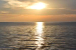 zonsondergang over de oceaan. wazig oceaan landschap achtergrond en uitzicht op de zonsondergang. wazig abstracte kunst achtergrond in digitale bewegingseffect. foto