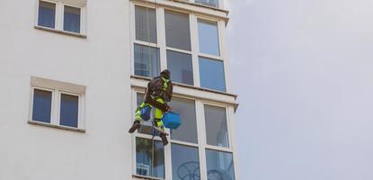 minsk, wit-rusland, mei 2022 - persoon die het raam van het gebouw schoonmaakt foto