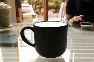 warme koffie in glas op glazen tafel met innerlijke patroon. foto