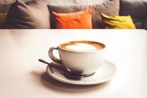 warme koffie op de witte tafel in het café bij de bank. foto