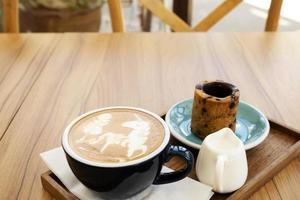 hete latte met koekjes op een houten tafel foto