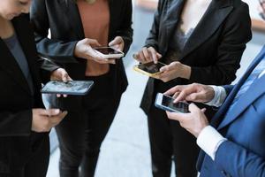 groep jonge zakenmensen staan en gebruiken smartphone samen concepten communicatie. foto