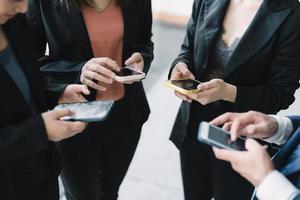 groep jonge zakenmensen staan en gebruiken smartphone samen concepten communicatie. foto