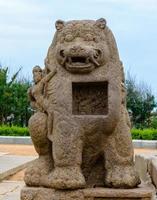 een oud stenen beeldhouwwerk van een leeuw en een hindoeïstische godheid in de 8e-eeuwse kusttempel in mamallapuram in tamil nadu, india. foto