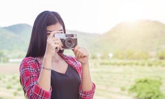 jonge hipster vrouw fotograaf met een vintage camera. foto