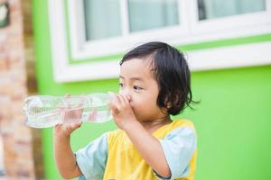 dorstig meisje drinkwater buitenshuis foto