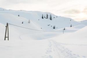 elektrische lijn overschrijding van een pad in de sneeuw foto