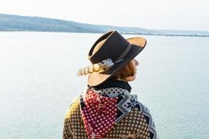 yong hipster vrouw reiziger in hoed en poncho buiten wandelen foto