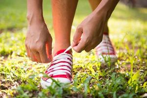 vrouw veter haar schoenen voordat joggen in het park