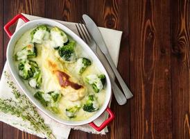 Kipfilet gebakken met broccoli in bechamelsaus op houten tafel. gezond eten, schoon eten foto