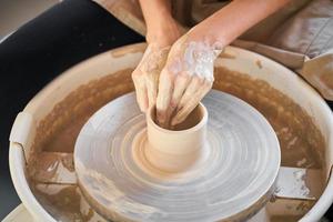 vrouw die keramisch aardewerk op wiel maakt, creatie van keramiek, handwerk, ambacht foto