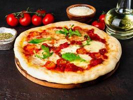 hete zelfgemaakte Italiaanse pizza margherita met mozzarella en tomaten foto