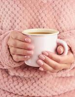warme koffie in de ochtend op koude herfstochtend, handen met een mok met een drankje, gezellige sfeer, verticaal foto