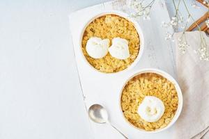 appelcrumble met ijs, streusel. ochtendontbijt op een lichtgrijze tafel. bovenaanzicht foto