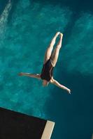 jonge vrouw duiken in het zwembad foto