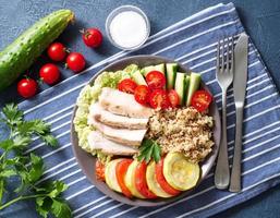 gezonde groente buddha bowl lunch met kalkoen, groenten en quinoa op blauwe achtergrond. bovenaanzicht. foto