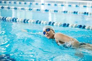 jong meisje in bril zwemmen borstcrawl slag stijl foto