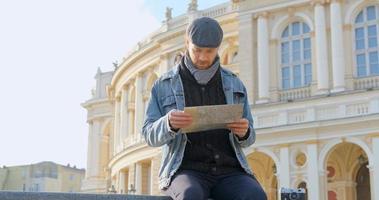 jonge mannelijke reiziger met kaart in de stad foto