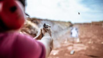 detailweergave van schutter die pistool vasthoudt en tactisch schieten traint, focus op pistool. schietbaan. foto