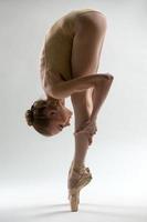 fragiele ballerina neemt een diepe helling naar voren foto