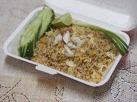 krabvlees gebakken rijst gegarneerd met roerei, stijl Thais eten in witte papieren doos lezen om te eten foto