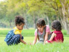 een groep jonge kinderen van vele nationaliteiten speelt en leert buiten school foto