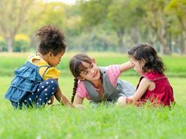 een groep jonge kinderen van vele nationaliteiten speelt en leert buiten school foto