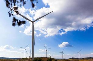 windturbines produceren schone energie elektriciteit op de achtergrond van blauwe lucht en wolken. foto