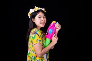 mooie aziatische vrouwen houden plastic waterpistolen vast bij een oude tempel tijdens songkran, het mooiste en leukste waterfestival in thailand foto