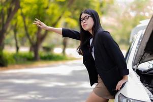 een jonge Aziatische vrouw zwaaide om hulp van een passerende chauffeur foto