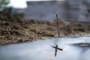 christelijk kruis gemaakt van hout op een achtergrond van zand foto