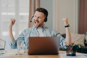 kaukasische bebaarde man geniet van succesvolle online onderhandelingen foto