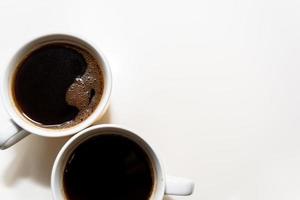 twee kopjes aromatische koffie op een lichte achtergrond. bovenaanzicht foto