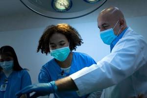 een medische professor geeft chirurgie aan medische studenten die aan het werk zijn foto