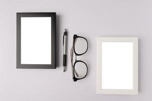 zwarte fotolijst, witte fotolijst, bril en pen op witte achtergrond foto