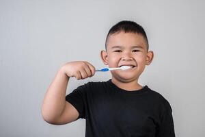 kleine jongen die zijn tanden poetst in studiofoto foto