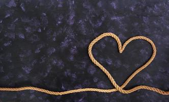 hartvorm gemaakt met touw op donkere achtergrond foto