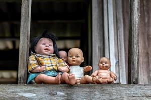 veel babypoppen zitten op oude houten huisbalkons. foto