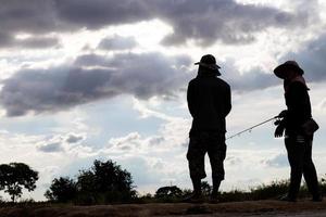 silhouet mannen en vrouwen staan te vissen. foto