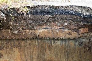 betonnen grindsteen onder de geërodeerde weg. foto