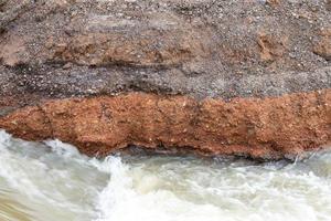 water onder de verharde weg weggesleten. foto