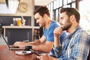 twee jonge mannen die werken op computers in een coffeeshop