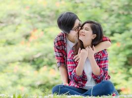 Aziatische vrouwelijke stellen lgbt zitten en ontspannen in de tuin en omhelzen elkaar in liefde en geluk foto